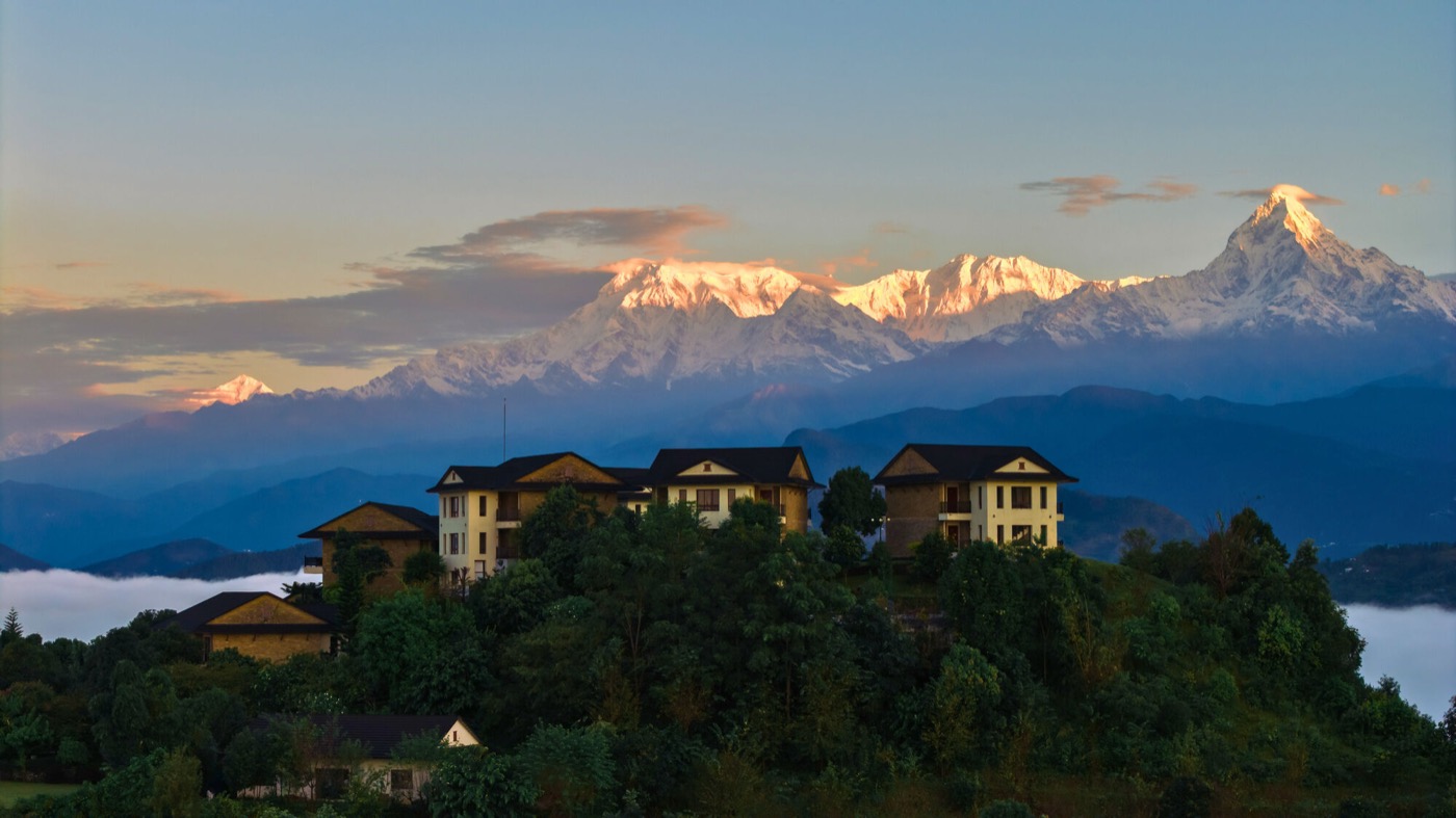 Rupakot Resort on its hilltop above the cloud, with the snow-covered Annapurna range behind
